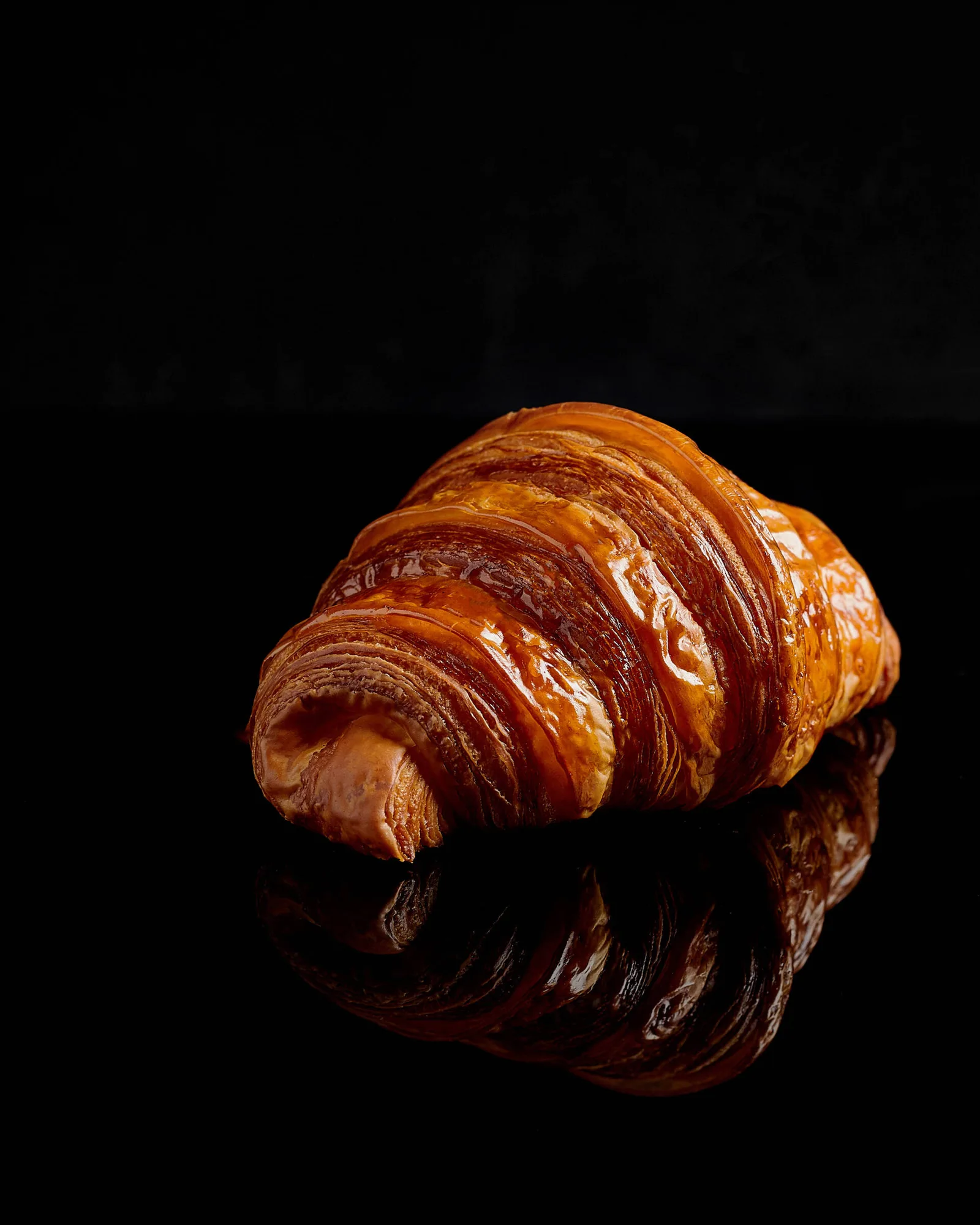 Traditional Croissant with reflection on black background